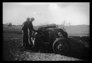 [Photograph of Men and Tornado-Damaged Vehicle]