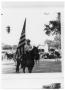 Primary view of Man on a horse bearing a flag during a parade