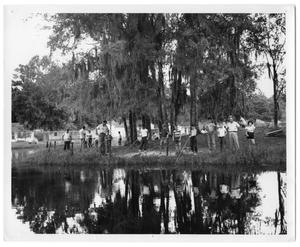 [Photograph of Group of People Standing near a Body of Water]