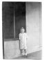 Photograph: [Child standing against wall]