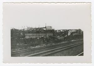 [Photograph of Destroyed Building Behind Railroad Tracks]