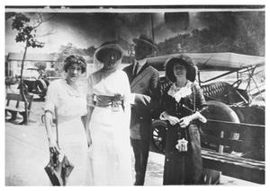[Three Women and a Man In Front of a Car]