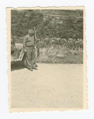 Primary view of object titled '[Man with a Rifle Leaning on a Jeep]'.