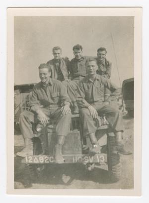 [Five Soldiers Sitting on Top of a Jeep]