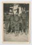 Photograph: [Four Soldiers Posing Together by a Truck]