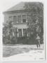 Photograph: [Soldier Standing in Front of a House]