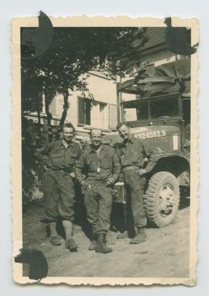 Primary view of object titled '[Photograph of Foncek, Arthur Fonjemie, and Joseph Pomagier Standing by a Truck]'.
