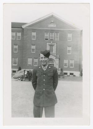 [G. F. Loyd Standing in Front of a Three-Story Building]
