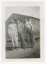 Photograph: [Three Soldiers Standing in  Front of Hutment]