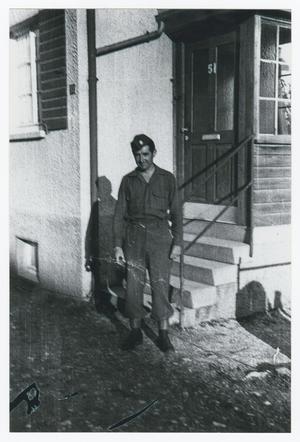 [Cecil Couts Standing near a House]