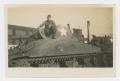 Photograph: [Soldier Kneeling on Top of Tank]
