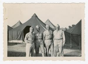 Primary view of object titled '[Four Soldiers Standing in Front of Tents]'.