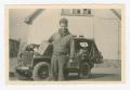 Primary view of [George Benack Standing in Front of a Jeep]