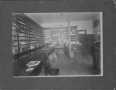 Photograph: [Interior of a hardware store. Two men in back of store.]