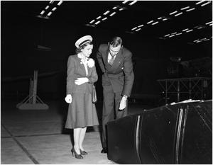 [George Newman and Helen Hayes inspecting a gas tank]