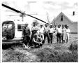 Photograph: Men and Women on the SMS Ranch Standing by a Bell Helicopter