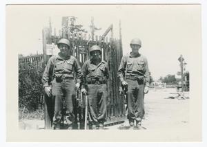 [Three Soldiers Standing by a Gate]
