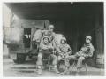 Photograph: [Four Soldiers with a Truck Beneath an Overhang]