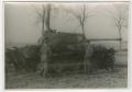 Photograph: [Two Soldiers by a Wrecked German Tank]