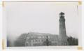 Photograph: [Lighthouse by a Large Building]