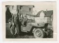 Thumbnail image of item number 1 in: '[Leonard Stewart Standing by a Jeep]'.