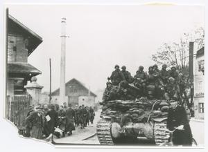 [Soldiers Riding a Tank in a Town]