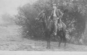 [W.E. Jones on horseback. Man dressed in dark suit.]