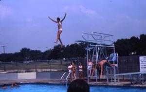[Two young women jumping off of diving boards]