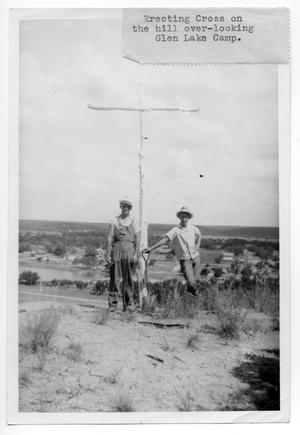 [Two men erecting a wooden cross near Glen Lake Camp]