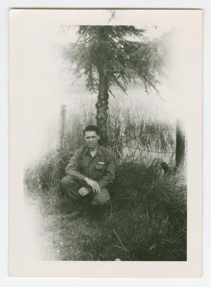 Primary view of object titled '[Jim Lineback Crouching Underneath a Tree]'.
