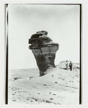[Photograph of Men by Rock Formation]