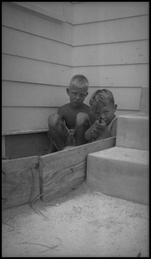 [Two Boys Crouching by a Stairway]