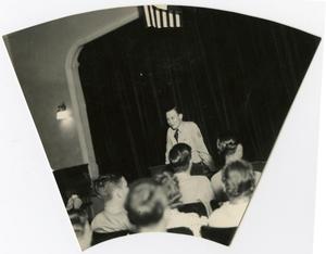 A Young Man Giving a Speech to a Crowd in the Auditorium
