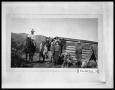 Photograph: Three Men and Two Women with Horses by a Cabin