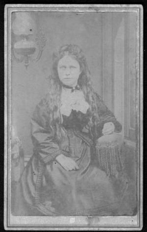 Primary view of object titled '[A woman wearing a dark-colored dress. She is sitting.]'.