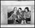 Photograph: Man with Two Women on Couch