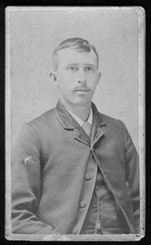 Primary view of object titled '[A young man in a jacket and vest with a striped necktie.]'.