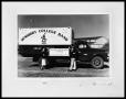 Photograph: Man and Woman Holding Sign by Truck