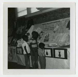 Primary view of object titled '[Children Looking at a Child Care Display]'.