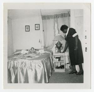 Primary view of object titled '[L. B. Allen Arranging a Bedroom]'.