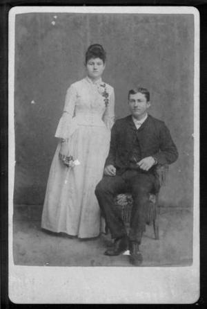 [A young couple, man is seated and woman is standing.]