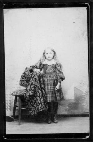 Primary view of object titled '[A young girl wearing a plaid dress.]'.