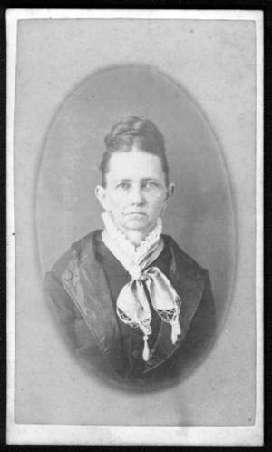 Primary view of object titled '[A woman wearing a dark dress with white ruffled stand-up collar.]'.
