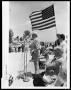 Photograph: Bob Hope Speaking Under U.S. Flag