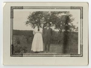 Primary view of object titled '[Alex and Winnie Freeman Standing by Trees]'.