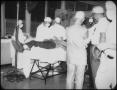 Photograph: [Medical Personnel Surrounding Bed]