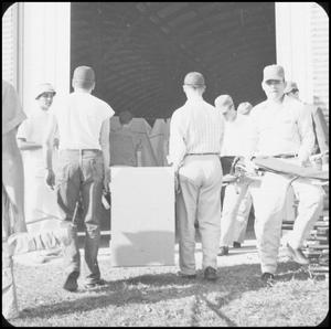 Primary view of object titled '[Men Carrying Equipment at Operation Recheck]'.