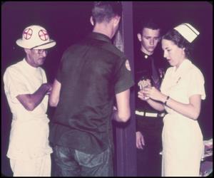 [Photograph of a Nurse with Three Men]