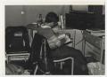 Photograph: [Photograph of Student Reading in Dorm]