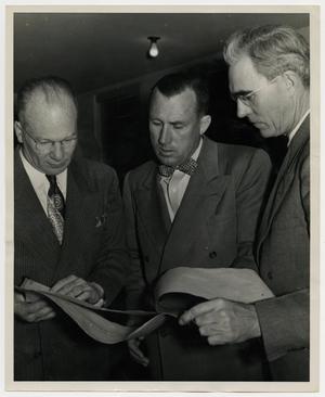 [Photograph of Three Men Looking at Papers]
